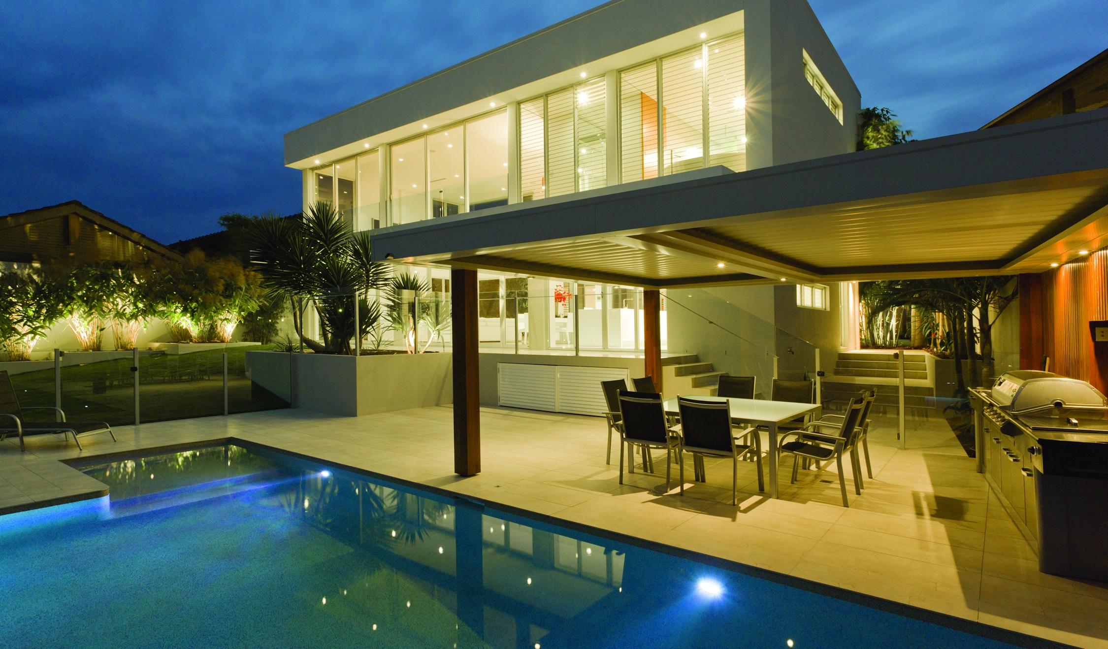 outdoor kitchen with a pool at night in the US south